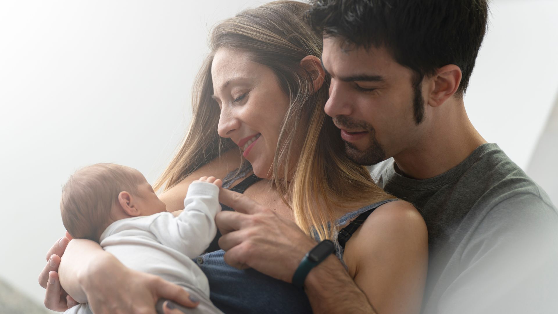 mamá y papá con bebé en brazos, imagen del ciclo de charlas de inauguración del centro infantil muyamama de Valladolid