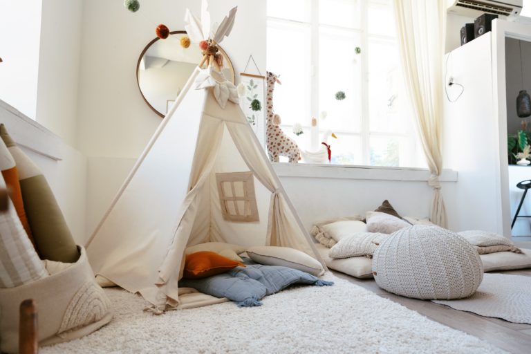 blog qué es muyamama. habitación infantil con una tienda tipi, una alfombra, cojines y una ventana